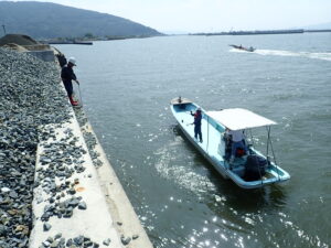 漁港の機能保全、補修設計のため、損傷箇所をスタッフが撮影しています。