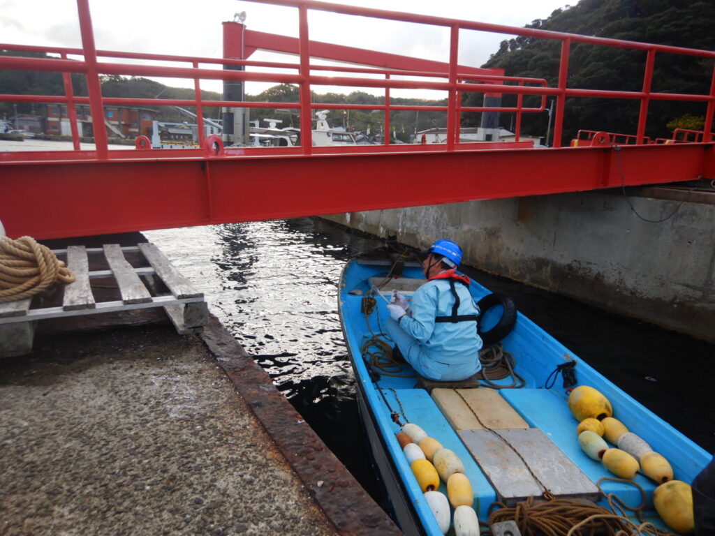 福岡の橋梁点検の際、スタッフが橋桁の下を点検しています。